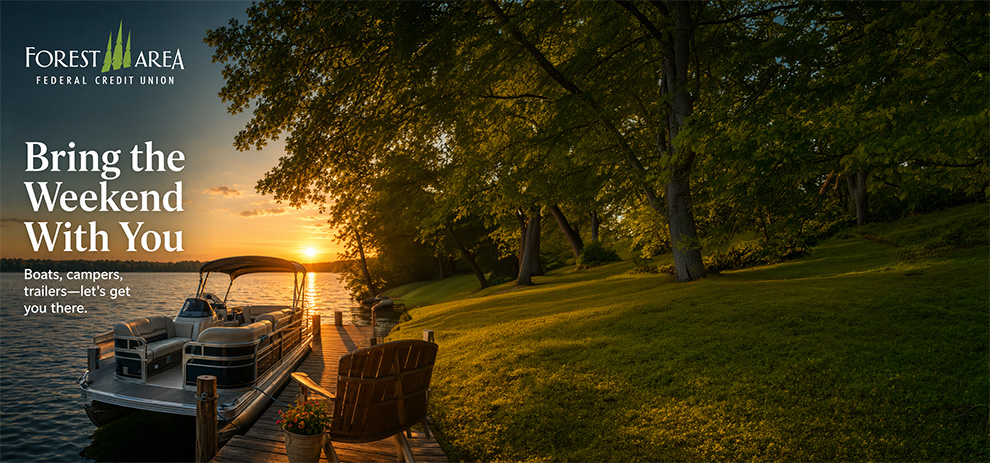 A pontoon boat tied to a dock on a lake in northern Michigan with the sun setting in the distance