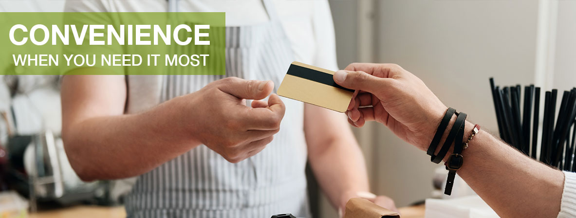 a hand gives a debit card to another hand for payment. The text "Convenience When You Need It Most" is in the upper left corner of the image